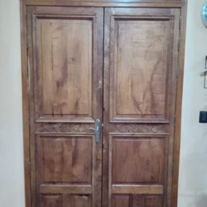 Puerta de punto buscado de dos hojas, tableriada con grabados y molduras sobrepuestas en madera solida de mezquite